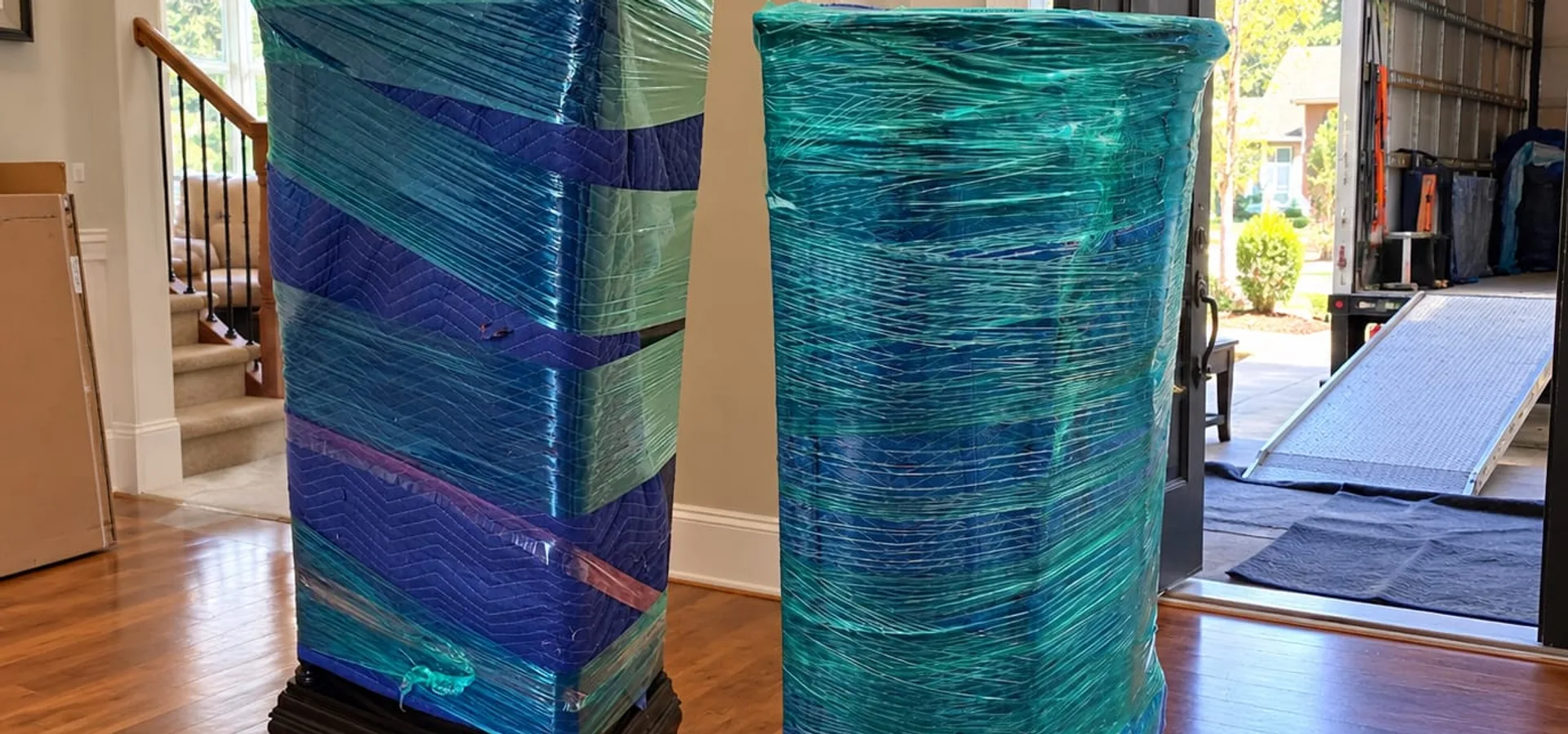Furniture wrapped in moving blankets and stretch wrap for a white glove move in a Fraser Valley home